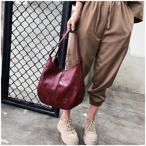 Detailed view of burgundy vintage leather tote bag with unique stitching and texture