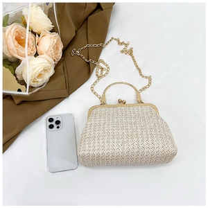 Close-up of beige woven shell bag featuring a gold arch handle and sphere clasp closure