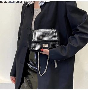 Dettaglio elegante borsa a tracolla nera con strass argentati e catena in metallo