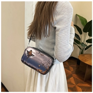 Détail du sac bandoulière d'Halloween avec imprimé citrouille porté par un mannequin