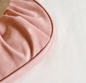 Detailopname van de roze geplooide handtas met zachte textuur en fijne afwerking