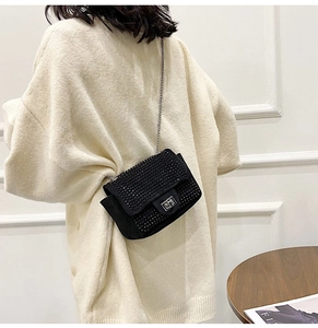 Dettaglio mini borsa a tracolla nera con strass e catena argentata sul retro modella