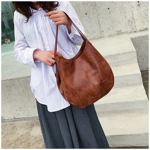 Detail of vintage brown faux leather tote with unique geometric patchwork and wide strap