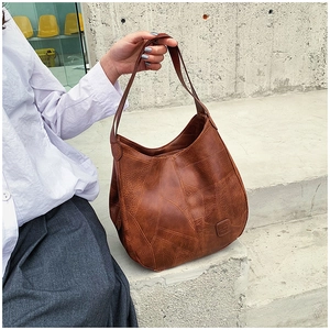 Detailed patchwork leather texture and vintage logo on a large brown tote bag