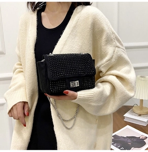 Dettaglio dell'elegante borsa a tracolla con strass neri e chiusura a girello in metallo