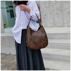 Detail of a large vintage dark brown tote bag styled with a minimalist outfit