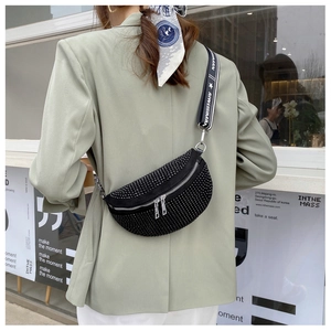 Nahaufnahme der sichelförmigen Strass-Brusttasche mit Kristallbesatz und Jacquard-Gurt