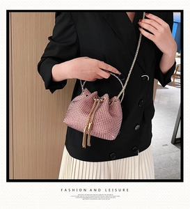 Détail du sac seau en strass rose avec poignée anneau dorée et cordon à glands