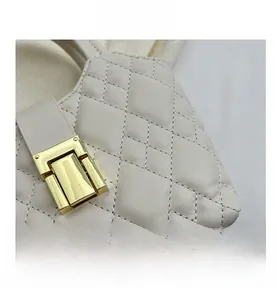 Detail of cream quilted leather handbag with elegant rectangular gold metal clasp