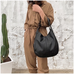 Detail view of a black pebbled leather hobo bag with a spacious minimalist shoulder design