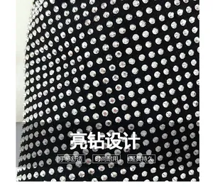 Detailed close-up of sparkling silver rhinestones on high-quality black fabric of a tote bag