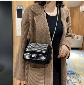 Dettaglio della borsa a tracolla con strass neri, catena argento e chiusura a scatto