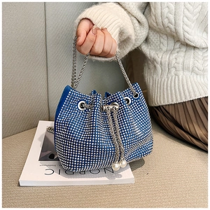 Détail du sac seau bleu en strass avec cordon en perles et bandoulière en chaîne argent