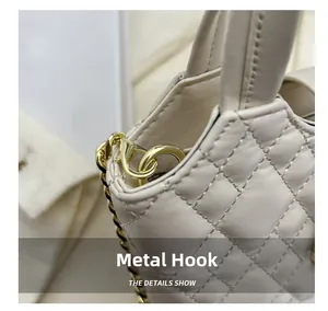 Detail shot of the golden hardware spring hook and quilted cream leather on the handbag