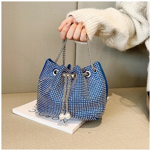 Détail du sac seau bleu à strass avec chaîne argentée et ornements de perles sur le cordon