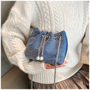 Gros plan du sac seau bleu en strass avec chaîne argentée et breloques en perles