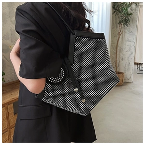 Close-up of black tote bag featuring shimmering silver rhinestones and a secure zipper