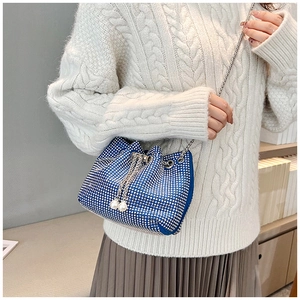 Détail du sac seau bleu en strass avec cordon et chaîne en argent sur modèle