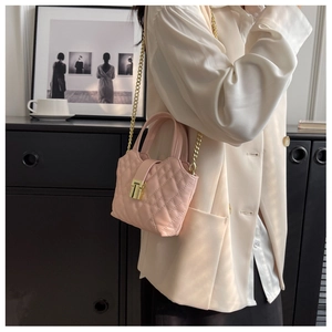 Detail of light pink quilted leather mini bag with gold chain strap and metal lock