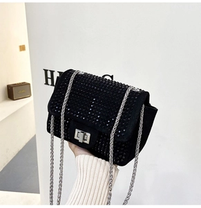 Dettaglio borsa a tracolla con strass neri scintillanti, catena d'argento e chiusura in metallo