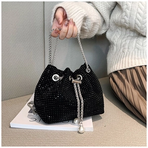 Détail du sac seau noir en strass avec chaîne argentée et perles blanches sur le cordon