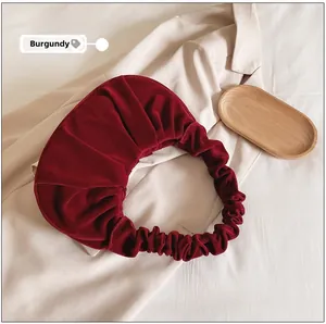 Detailopname van de wijnrode fluwelen wolktas met een elegante geplooide handgreep