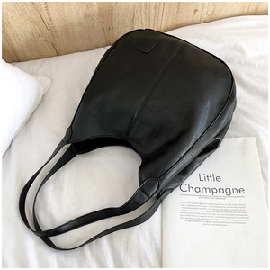 Detail showing the grainy texture of the black soft leather shoulder bag with logo