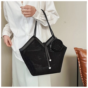 Close-up of black rhinestone tote bag with trapezoid structure and round charm detail