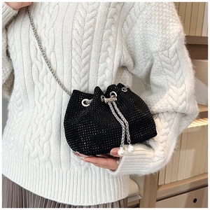 Détail du sac seau en strass noir avec bandoulière chaîne argentée et glands en perles