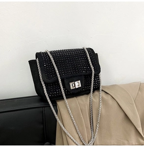 Dettaglio della borsa a tracolla con strass neri, catena argento e chiusura girevole
