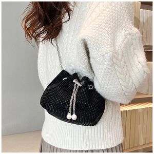 Détail du sac seau noir en strass avec chaîne argentée et cordon de serrage perlé