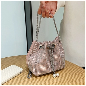 Gros plan du sac seau rose en strass avec fermeture à cordon et détails de perles