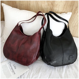 Detailed close-up of vintage faux leather tote bags in burgundy and black colors