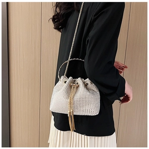Détail du sac seau à strass scintillants avec poignée en anneau doré et cordon à glands