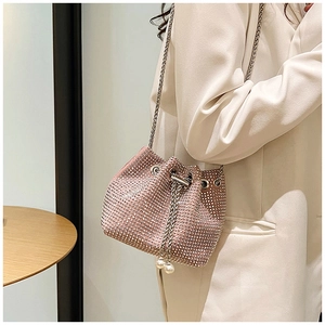 Détail du sac seau rose en strass avec cordon en perles et bandoulière en chaîne
