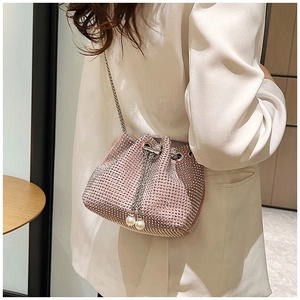 Détail d'un sac seau rose orné de strass avec cordon en perles et bandoulière chaîne