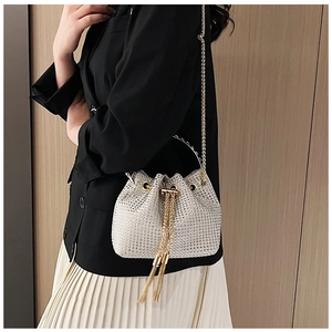 Détails du sac seau à strass étincelants avec chaîne dorée et finitions à pompons chic