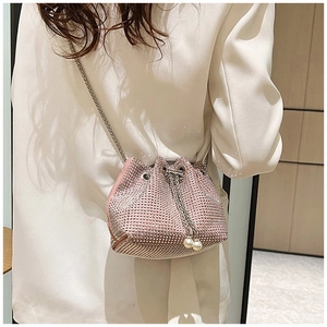 Détail du sac seau en strass rose avec perles de serrage et bandoulière en chaîne