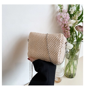 Detail of hand-woven straw bag texture with elegant silver chain and beige fiber