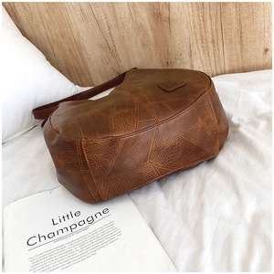 Detailed close-up of retro brown faux leather shoulder bag with geometric quilted pattern