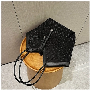 Detail of black rhinestone tote bag with matching round coin purse on a wooden stool