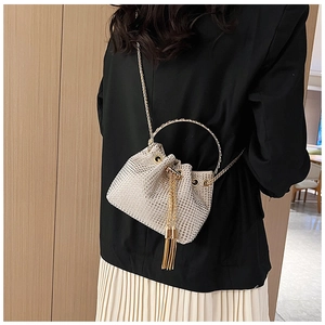Détail d'un sac seau scintillant en strass avec poignée dorée et gland élégant