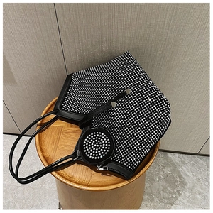 Detailed close-up of a black tote bag with silver rhinestones and matching round purse