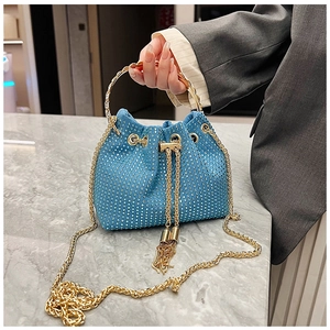 Détail du sac seau en strass bleus avec poignée dorée, chaîne et glands métalliques