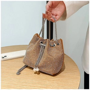 Détail du sac seau marron avec strass, anse en chaîne argentée et ornements en perles