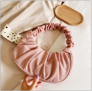 Detailweergave van de roze geplooide cloud bag met zachte textuur en handvat
