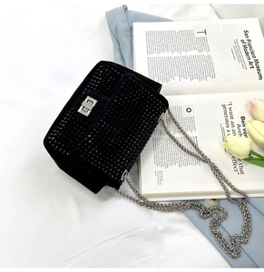 Vista macro della borsa con strass neri con chiusura a scatto e catena in metallo argento