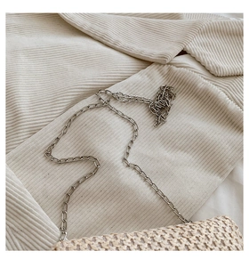 Close-up of the beige straw woven texture and silver metal chain strap for a summer bag