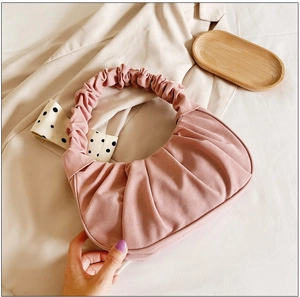 Close-up van roze geplooide cloud-handtas met zachte textuur en elegant ontwerp