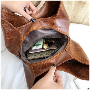 Interior view showing the large capacity and zippered pocket of the brown tote bag